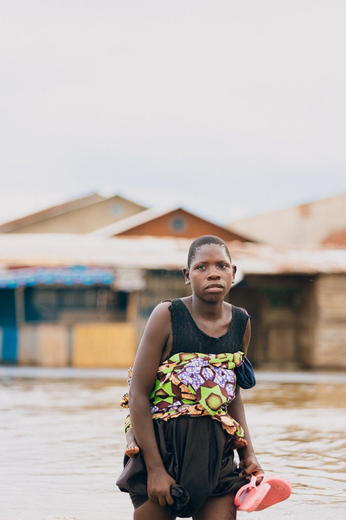 gallery-1 A teenager stands in a flooded rural village, capturing the impact of the environment.