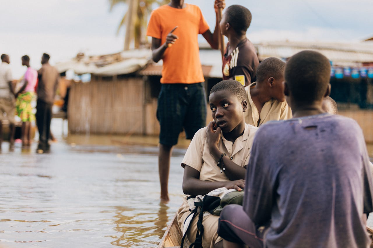hero-img-02 Children in rural village navigate flood waters, depicting resilience.