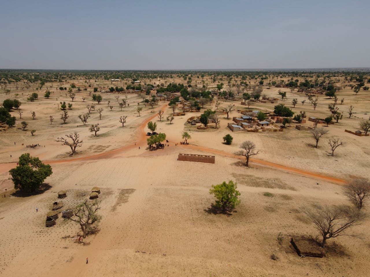 services-03 Aerial view of a dry rural landscape with sparse vegetation and scattered homes.